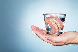 Dentures soaking in a glass of water