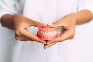 Lady presents viewer with dentures