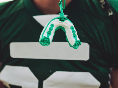 Athletic mouthguard hanging from football helmet