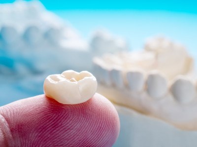 Closeup of a finger holding a molar crown