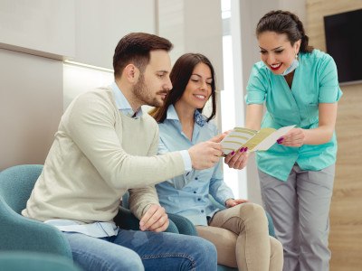 Dental team member showing a financing brochure to patients