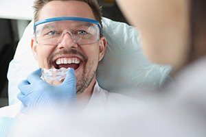 A dentist providing a man with a custom mouthguard