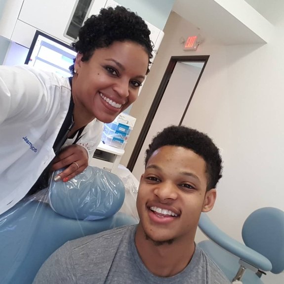 Fort Worth dentist smiling next to patient in dental chair