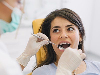 Dental patient having her mouth examined after wisdom tooth extractions